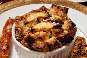 baked french toast in a white cup with baked pineapple on the side.