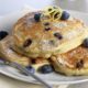 Ricotta Pancakes with blueberries on a white plate.